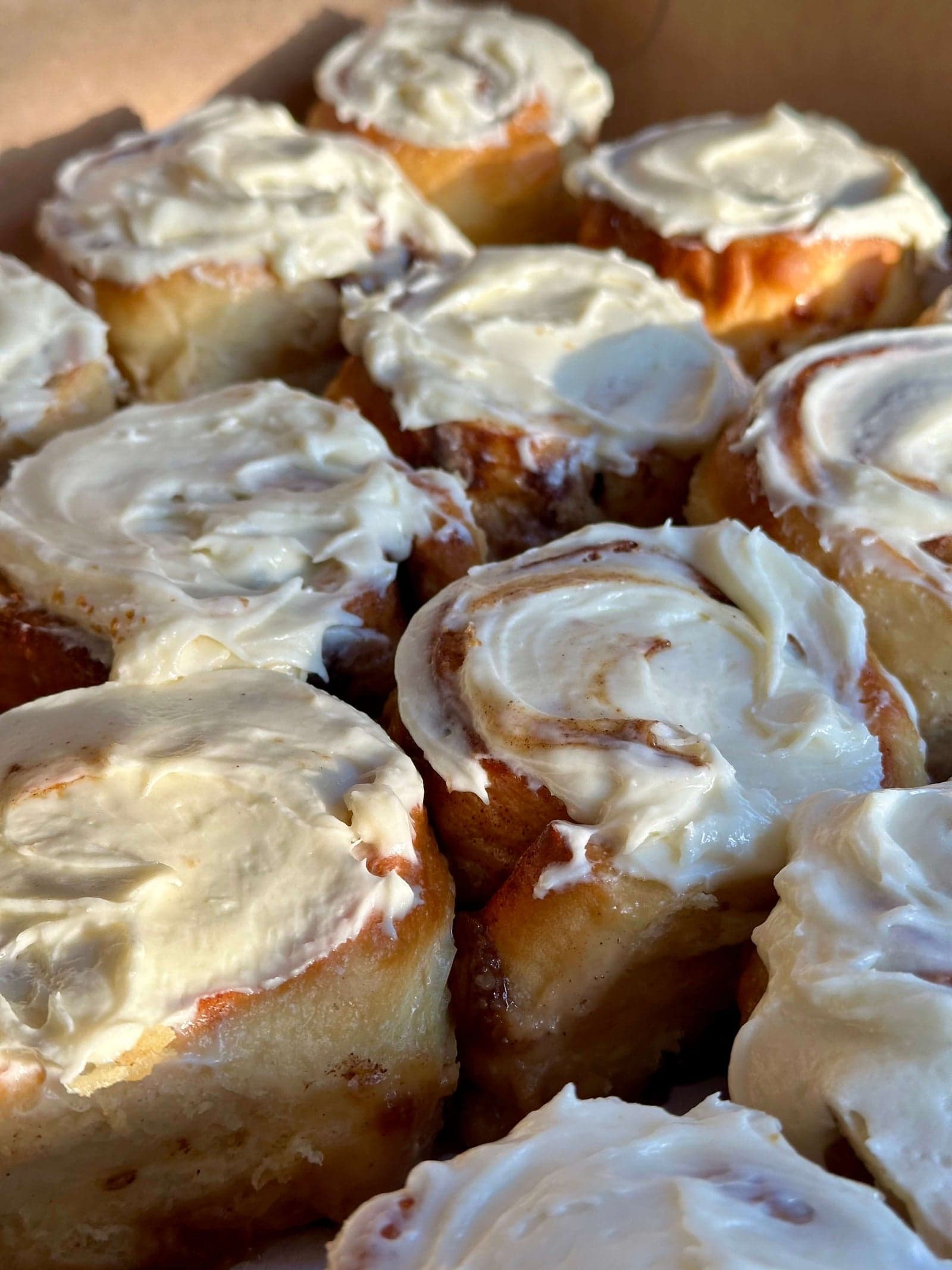 A box of frosted cinnamon rolls ready to travel